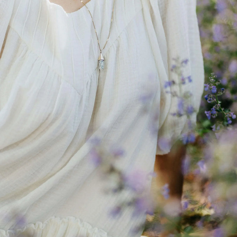 A close view of a person holding flowering stems in daylight.