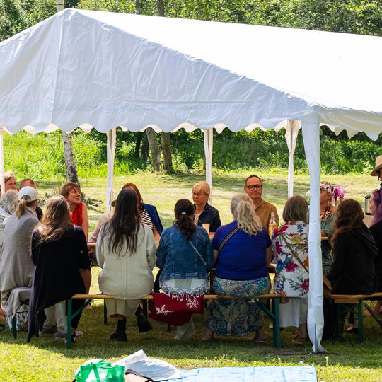 People gathered around tables at an outdoor Ecosh event.