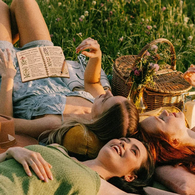 People relaxing together on a picnic blanket outdoors.
