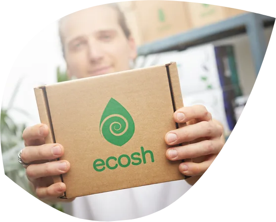 A person holding an Ecosh cardboard delivery box.