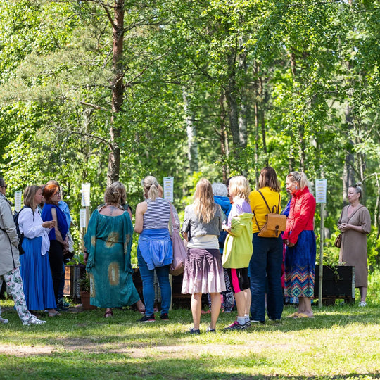 A group of people gathered in a green garden at an Ecosh event.